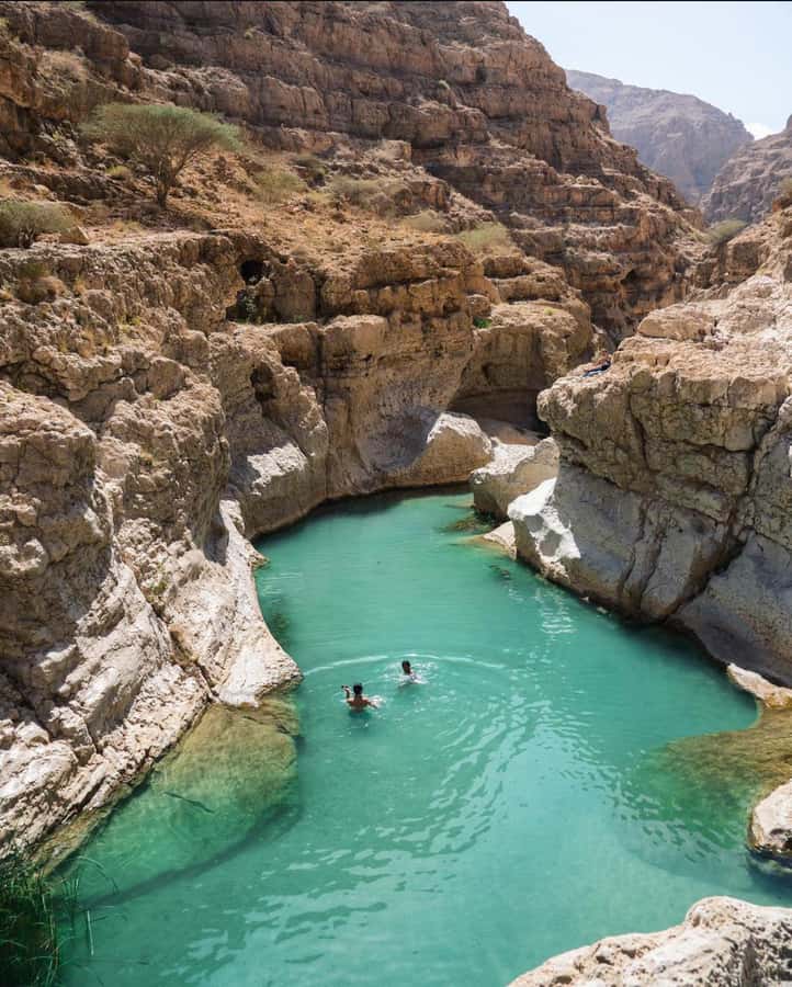 Muscat: Wadi Shab & Bimmah Sinkhole Tour with Pickup & Lunch - Swimming toward the cave waterfall